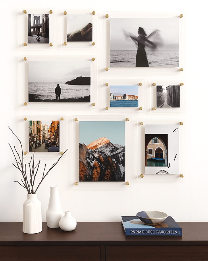 A gallery wall of nine floating frames in mixed sizes with gold standoffs