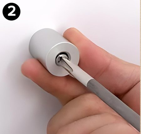 A screwdriver fastening a standoff base to the wall