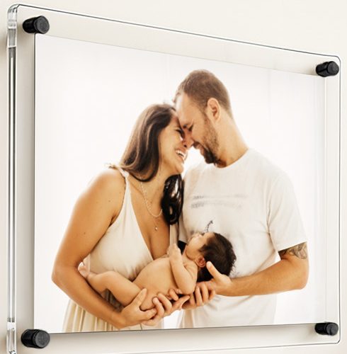 A family photo held in a clear acrylic floating frame with black standoffs