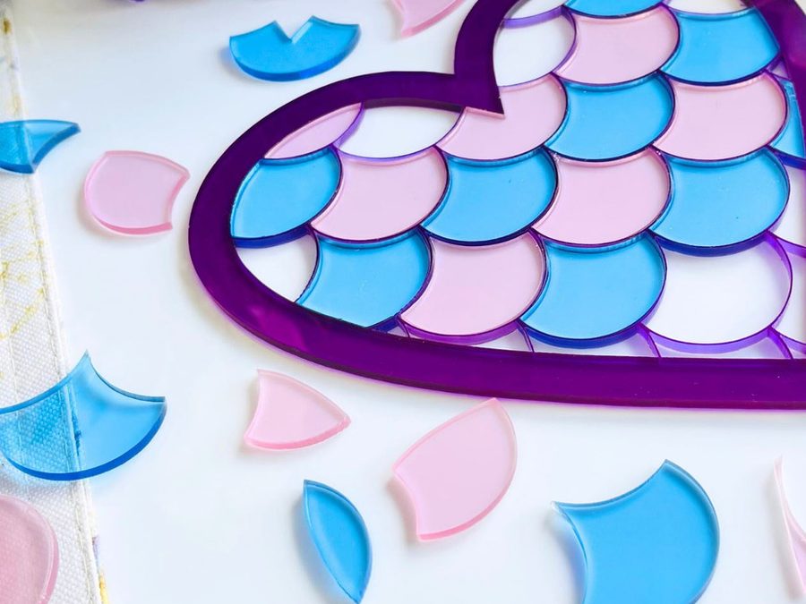 Laser-cut transparent acrylic heart and scale shapes in pink, blue and purple